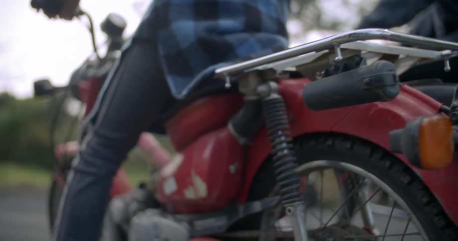 People sitting on their motorcycle on a small road