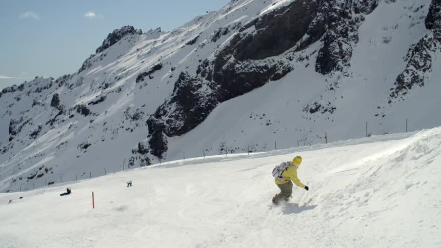 Man skiing down a hill beside a large mountain
