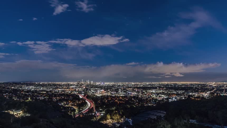 Clouds float over a city at sunset