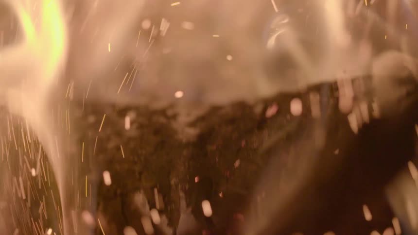 Fire being stirred as sparks fly