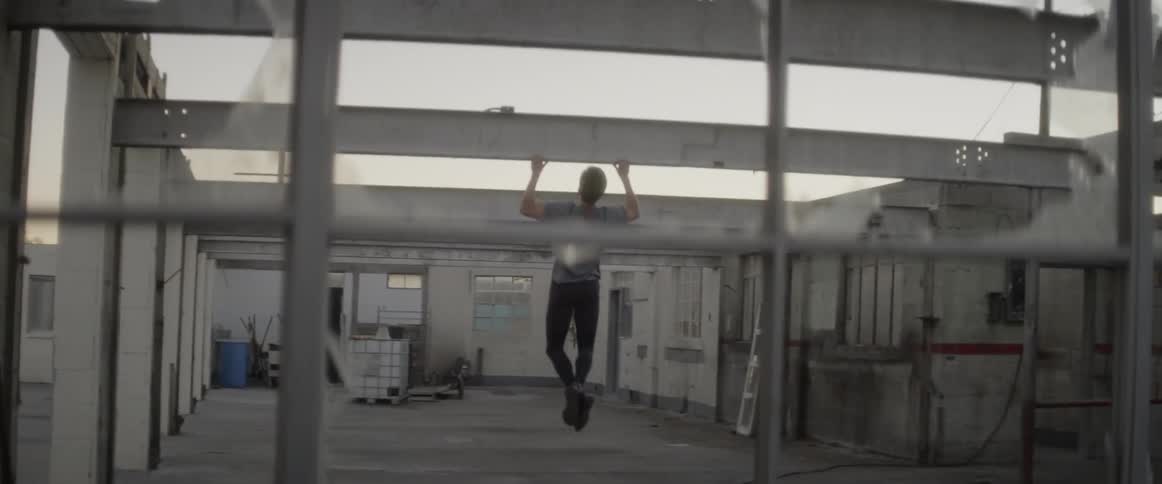 Man does pull ups on a metal beam