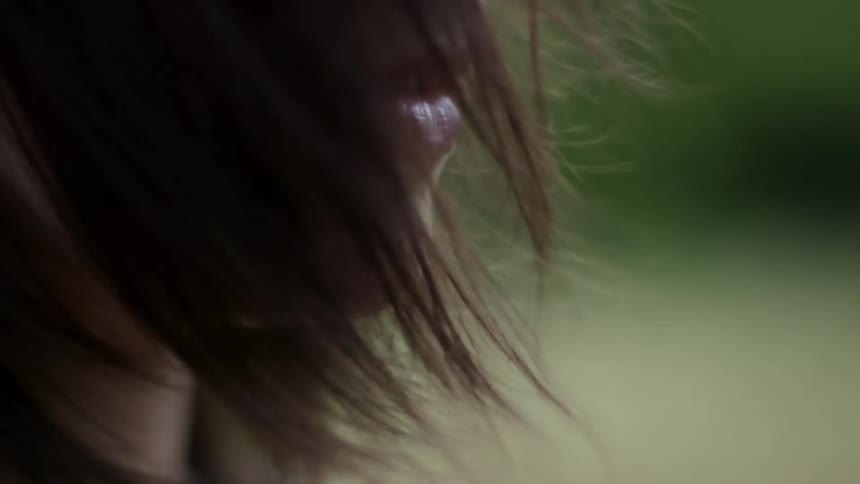 The wind blows a woman's hair across her face