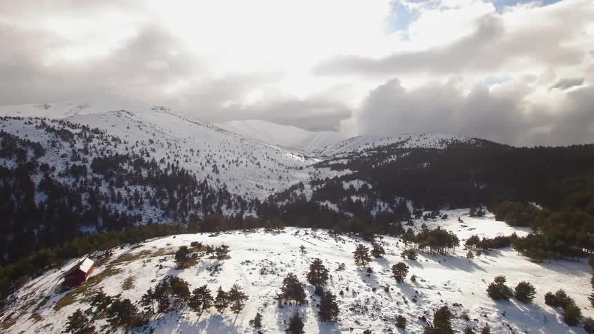 Clouds float over snowy mountains