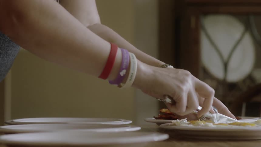 The person is cutting the food on the plate