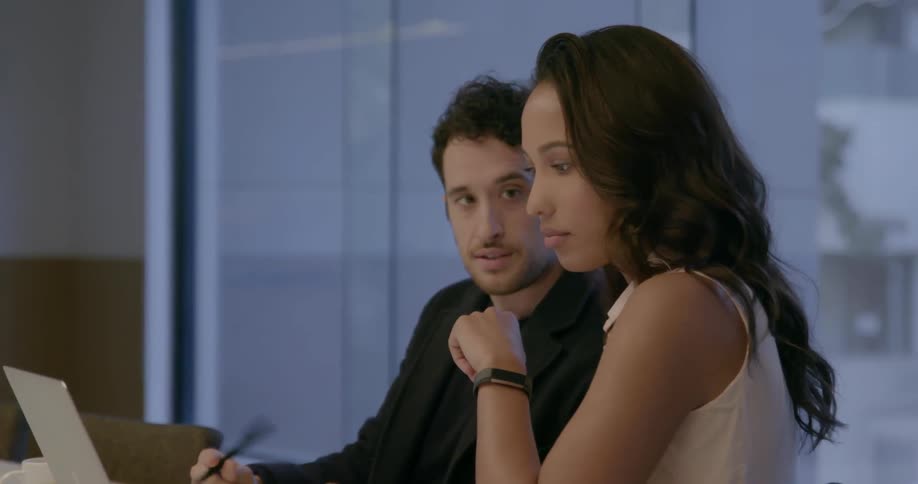 A woman nods her head while talking with a man in the office