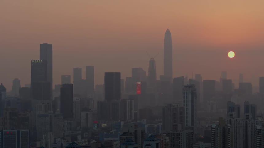 The sun sets over skyscrapers