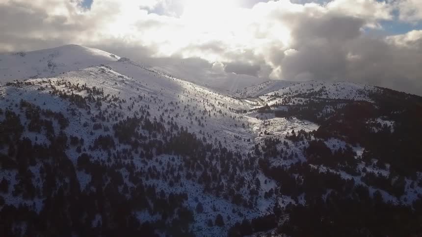 Clouds float above snowy mountains