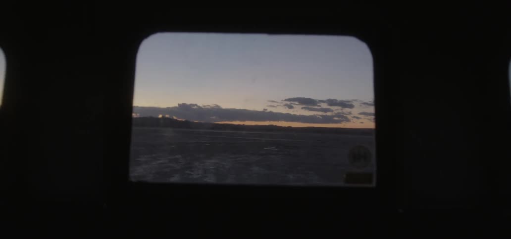 Vehicle drives across a rural field at sunset