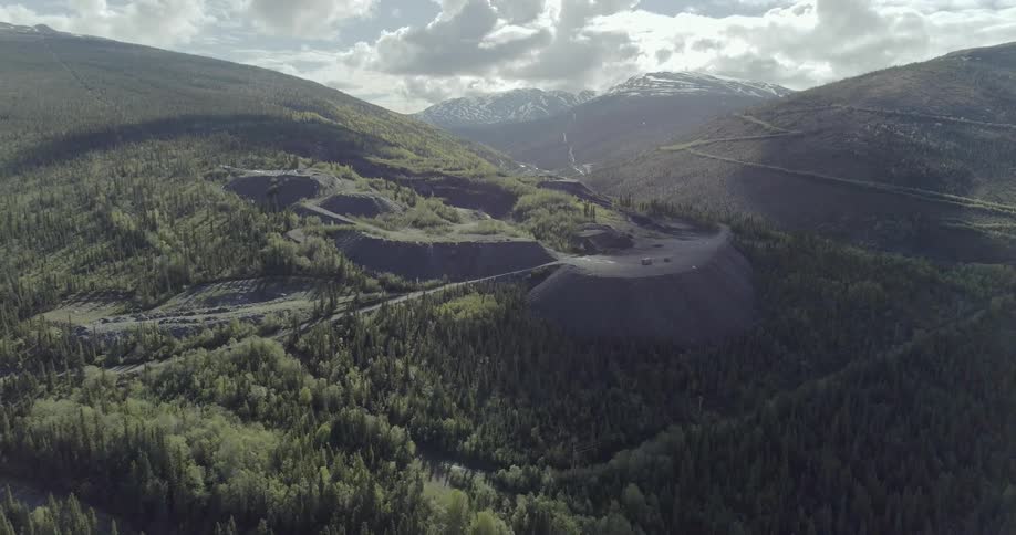 The hills are covered with trees and a single road