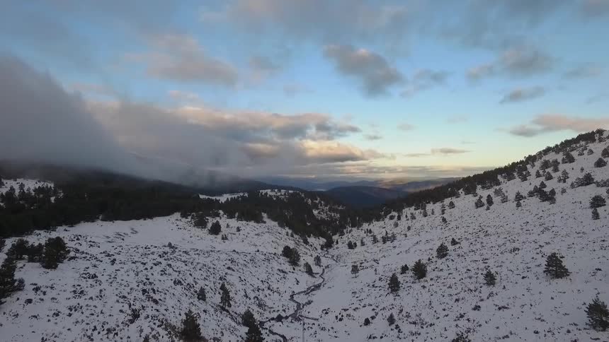 A road winds along the hills covered with snow