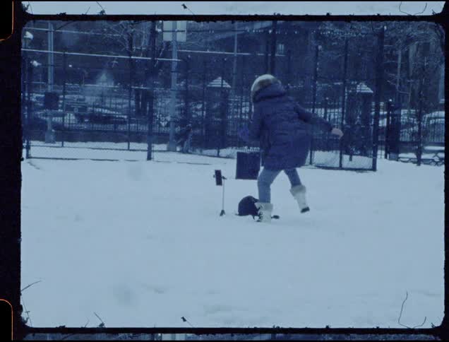 Woman sets up a camera in the snow