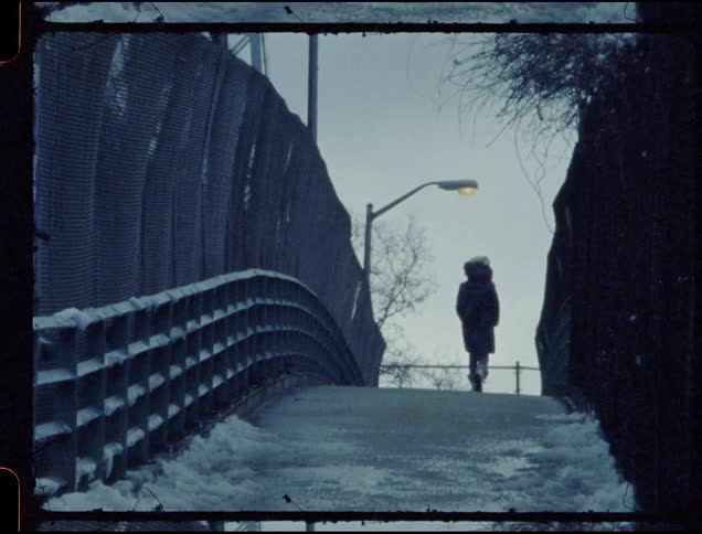 Person walks up a bridge towards a streetlight