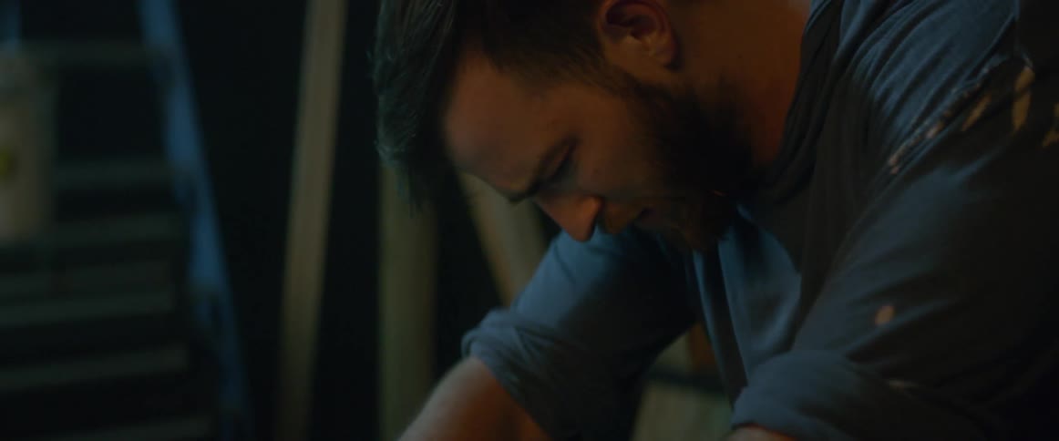 The man is leaning forward crying