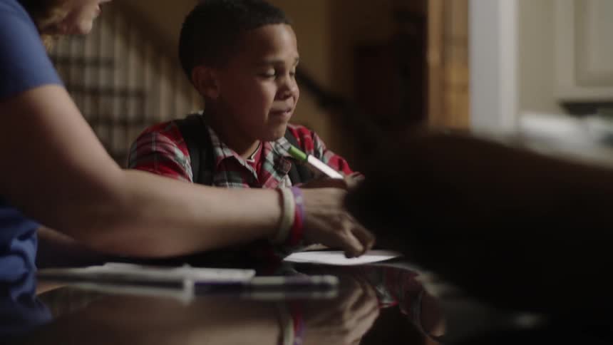 A woman helps a boy with some homework
