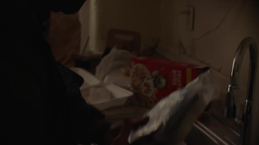 A swat team officer searches through a kitchen