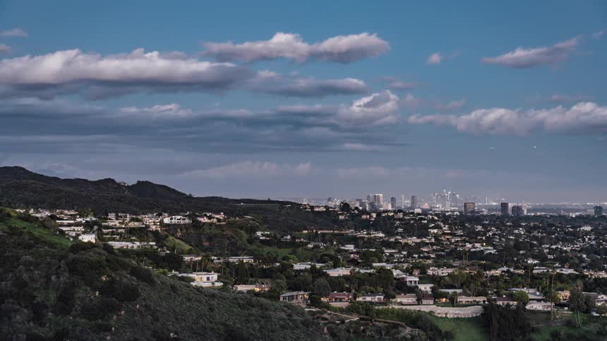 Clouds float over a city at sunset