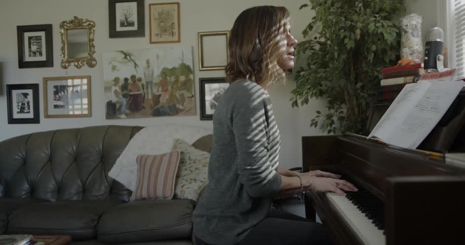 A woman is singing and playing piano