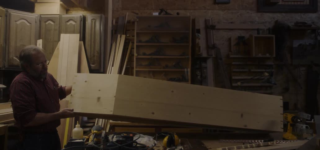 Carpenter builds a coffin in a workshop