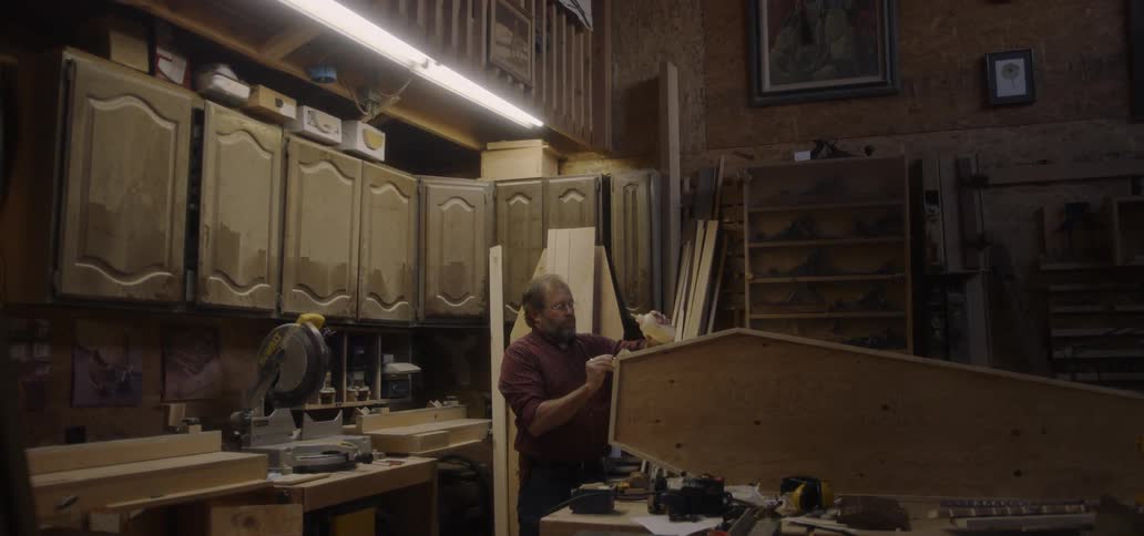 Man works on a wooden structure in a garage