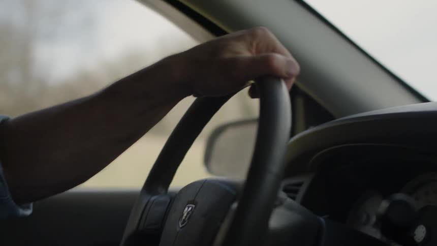A person turns the wheel around as they drive