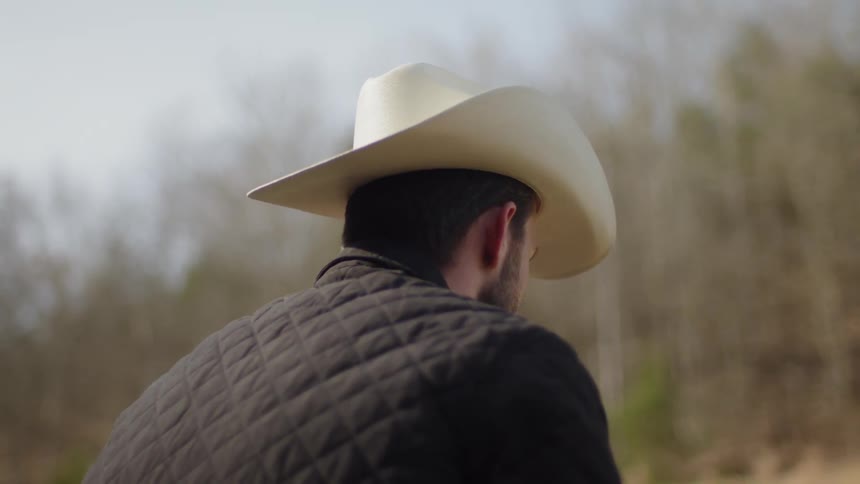 A cowboy stands outside