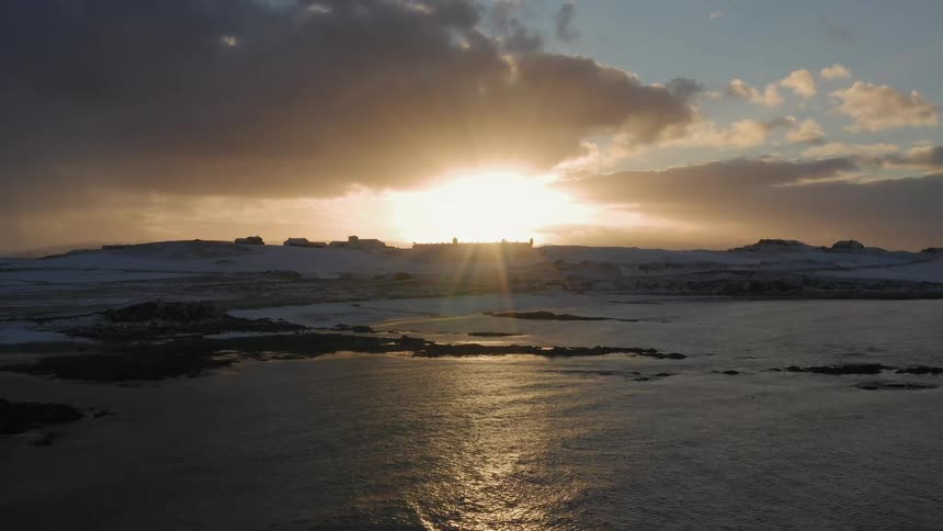 The sun sets over a coast