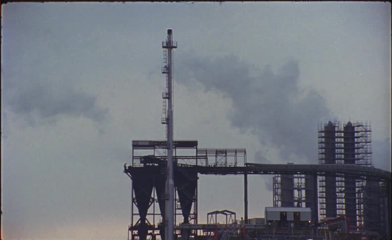 Smoke rises from a factory at sunset