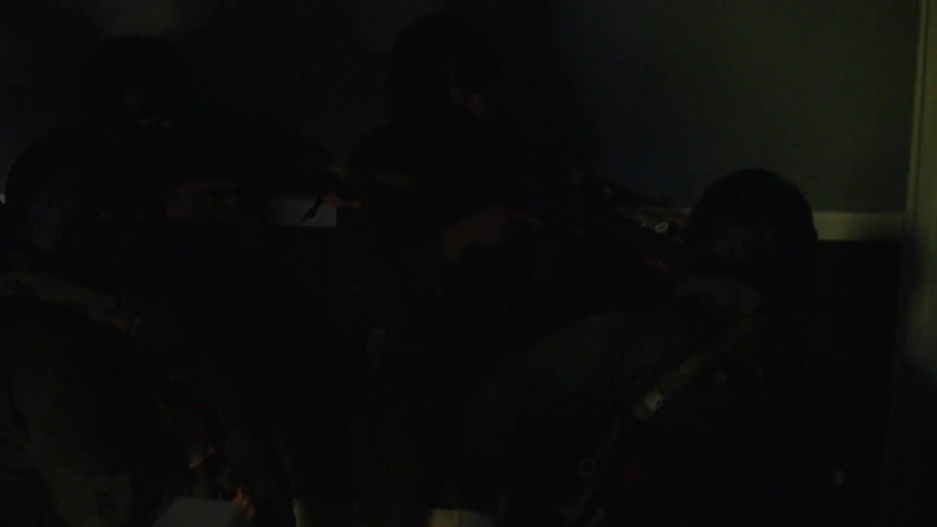 Officers in riot gear enter a home