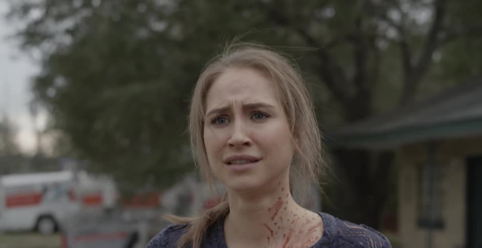 A woman emerges from a vehicle with blood on her neck