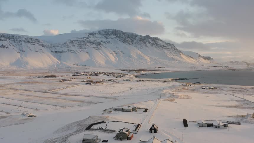 Tiny village on snowy ocean edge