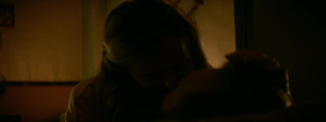A man and woman kiss on the couch
