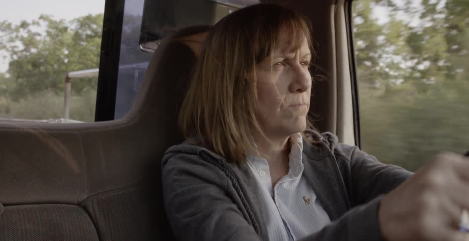 A woman drives a car on a sunny day