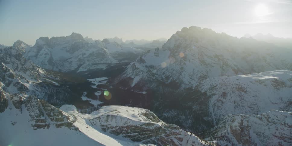Sun shines down on a snow covered mountain range