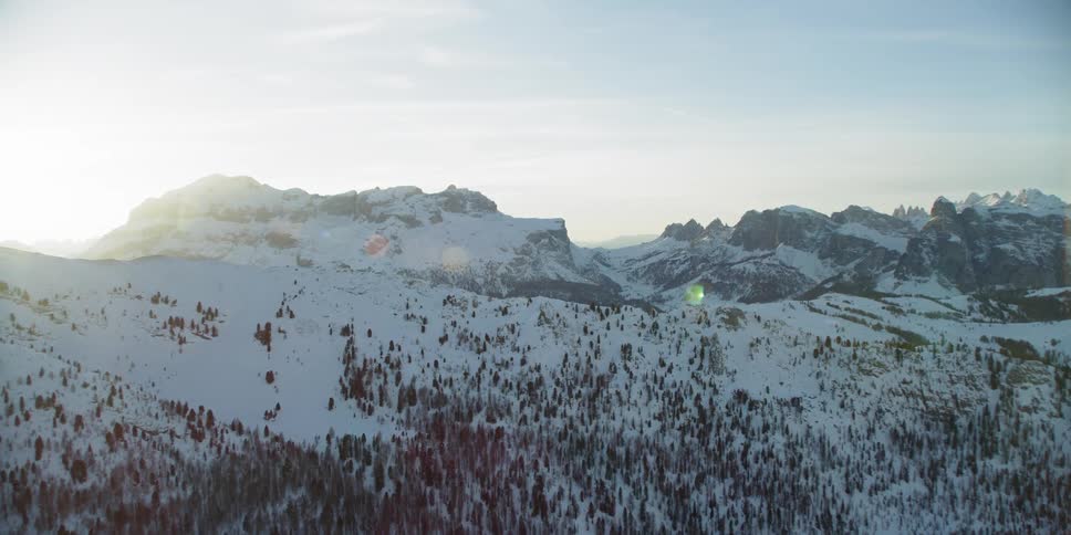 Mountains covered with snow and trees at sunset