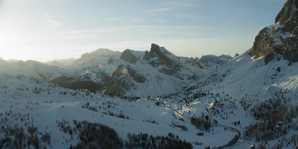 The sun sets over snowy mountains