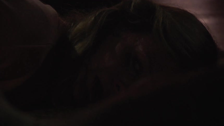 Terrified woman lays on floor as lights flash over her