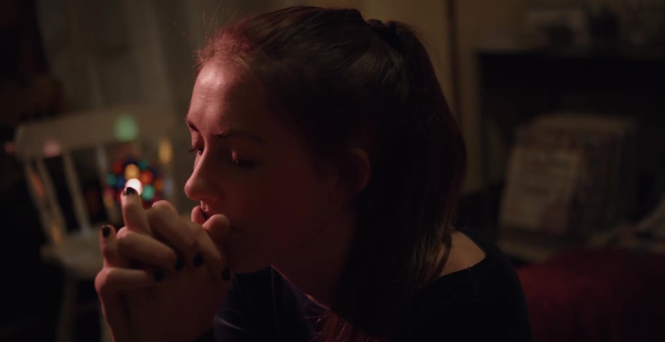 A woman talks with someone with her hands folded