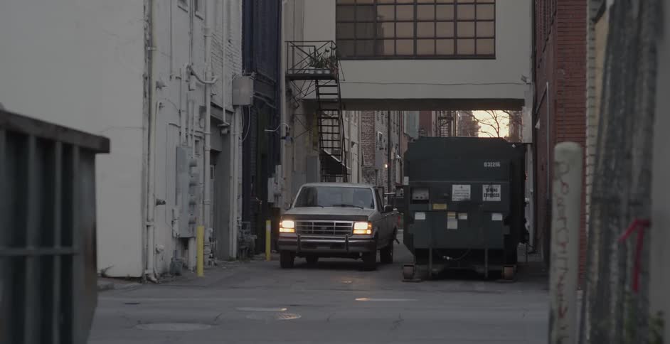 A truck turns the corner in the alley