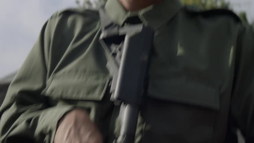 A soldier is carrying a rifle on the moving truck