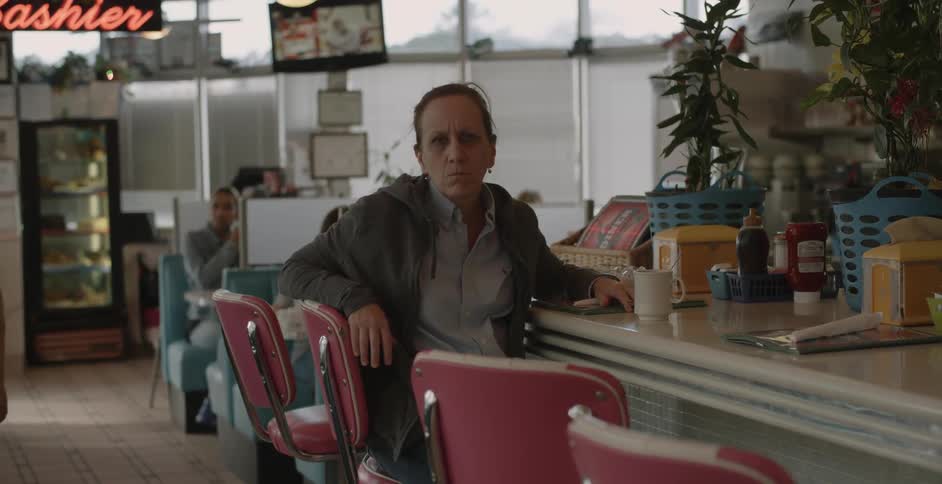 A woman turns in her seat at the diner counter