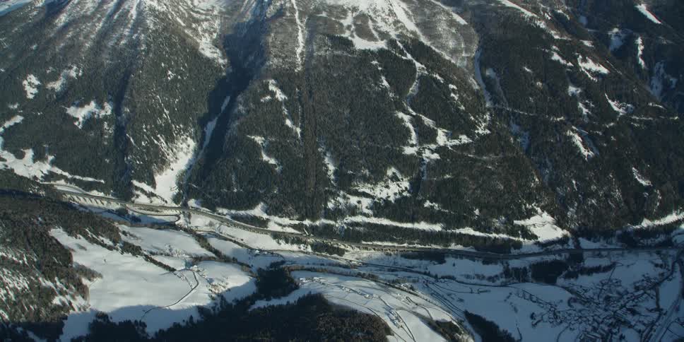 Below is a trail running along the snow covered mountain