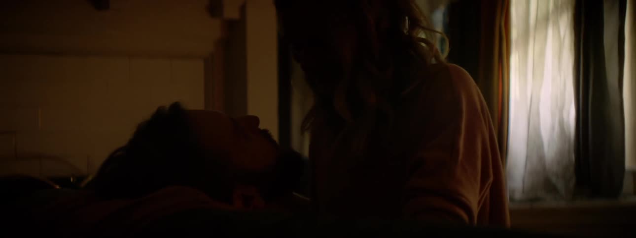 A man and woman make out on the couch