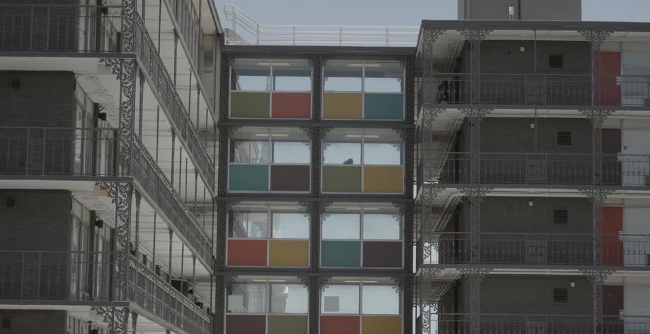 Children playfully run through an apartment complex