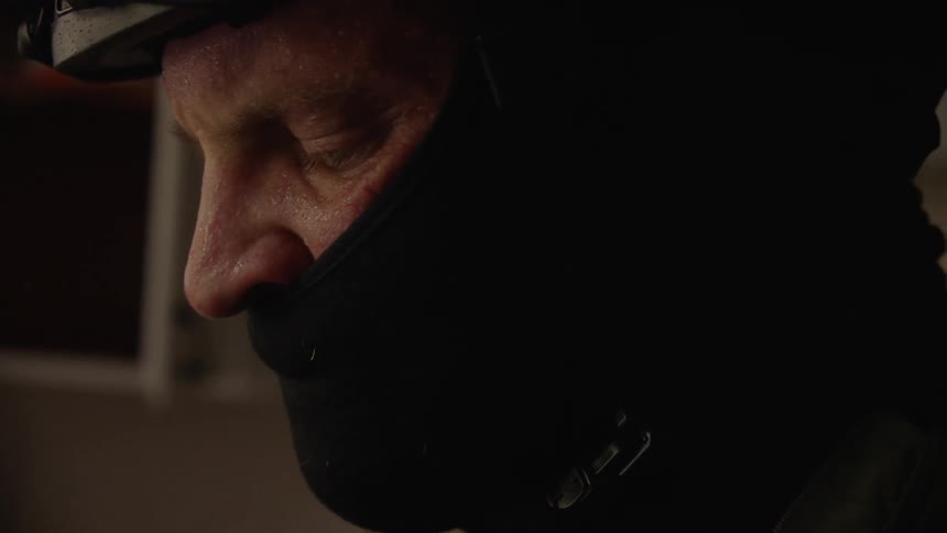 A man is talking with a mask on his face