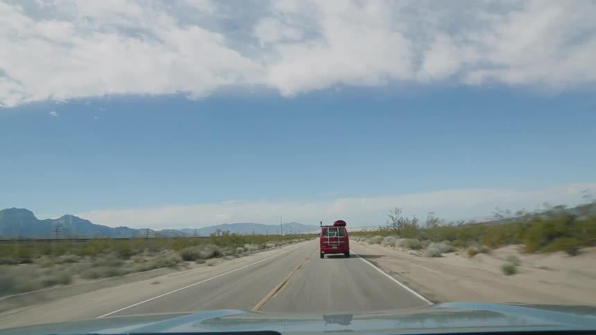 Vehicles travel on a road in the wilderness