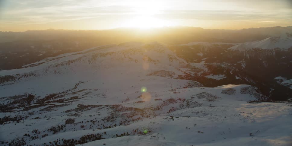 Sun shines down on a snow covered mountain range