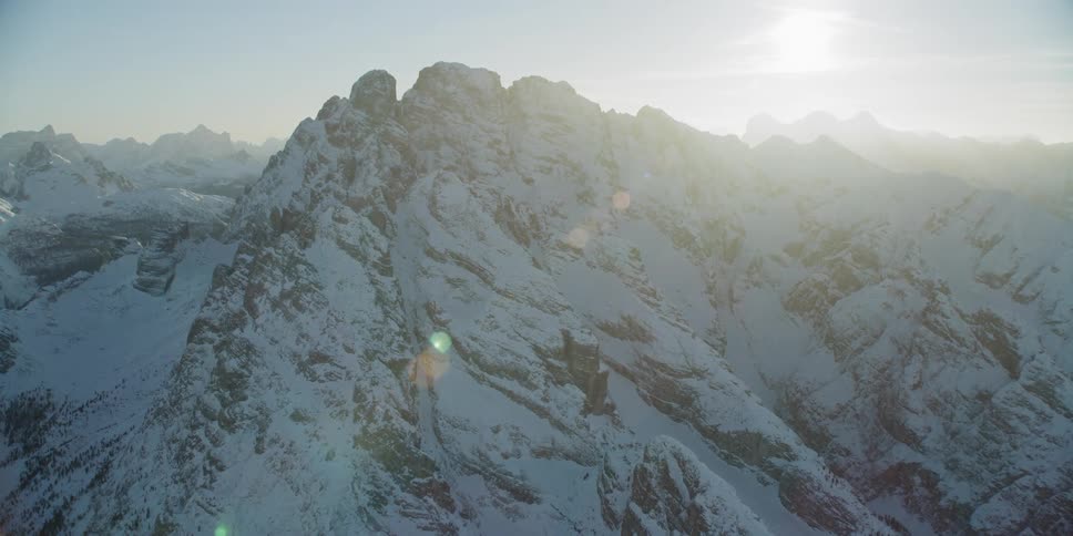 The sun shines over snowy mountains