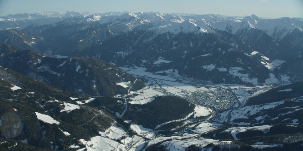 A town sits in the middle of the snow mountain ranges