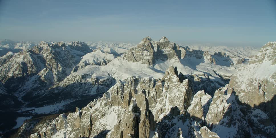 Sun shines down on a snow covered mountain range