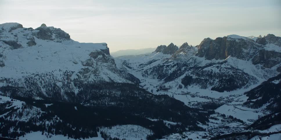 The wide mountain range has many trees and ice